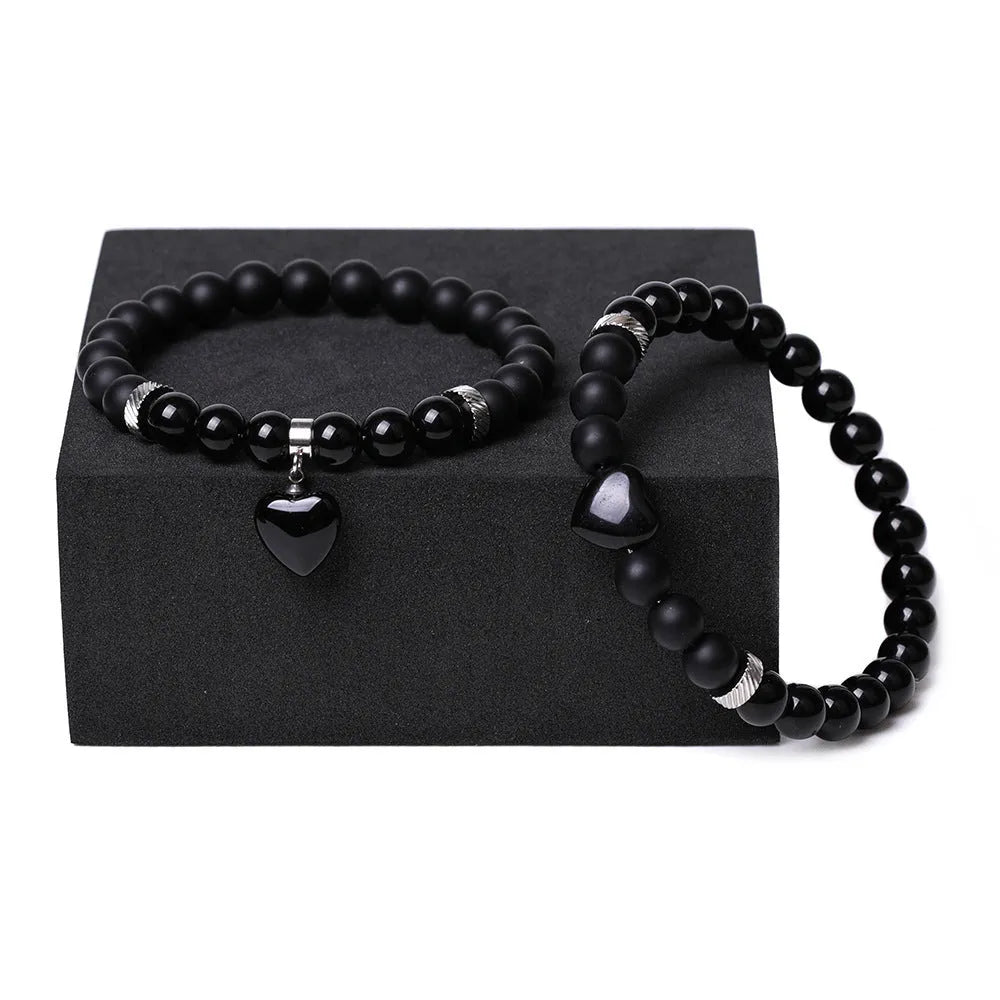Natural stone couple bracelet set showing two heart-shaped stone pendants on bracelets with geometry design elements