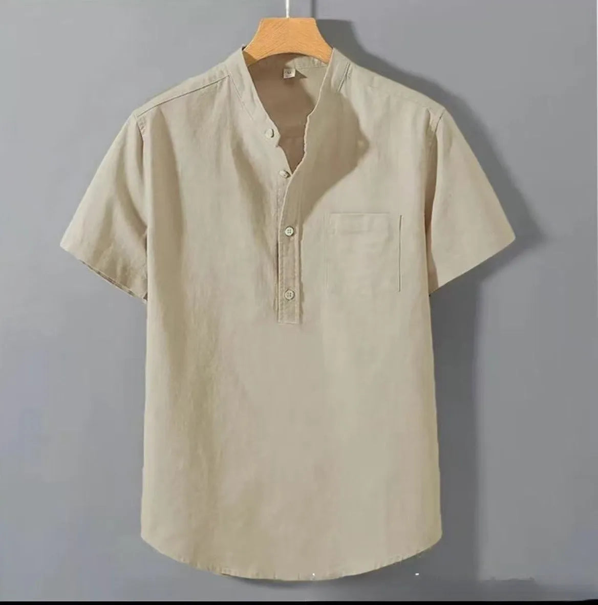 Man wearing a beige loose-fit linen casual shirt with a stand collar and short sleeves.