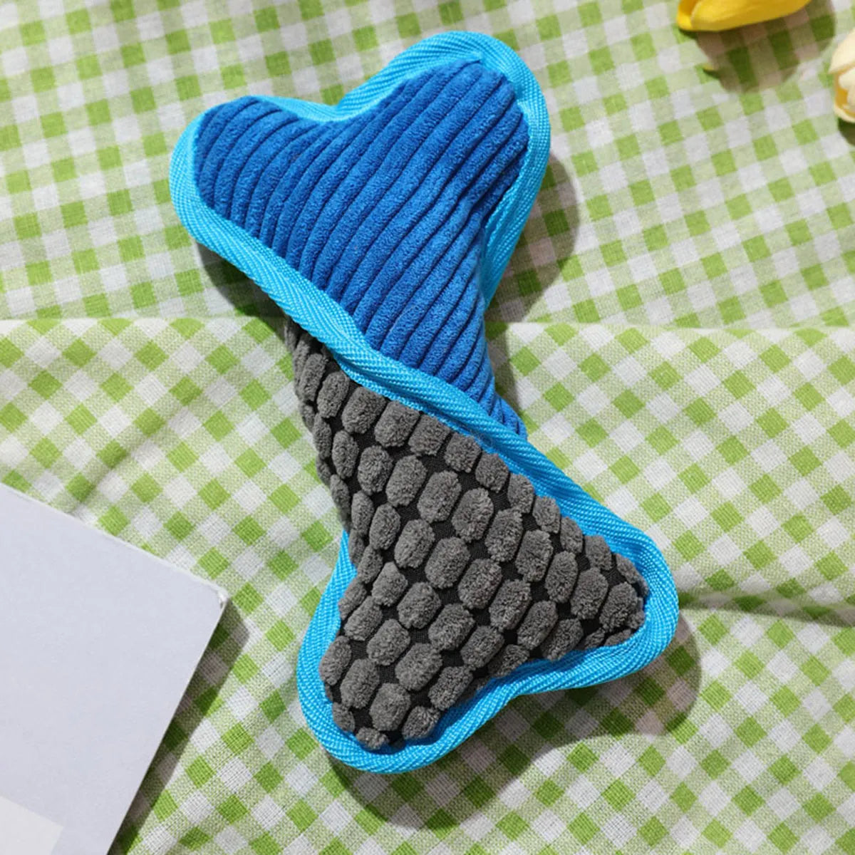 Blue teddy dog toy with squeaker bone, showing soft corn fleece lining and bite-resistant construction