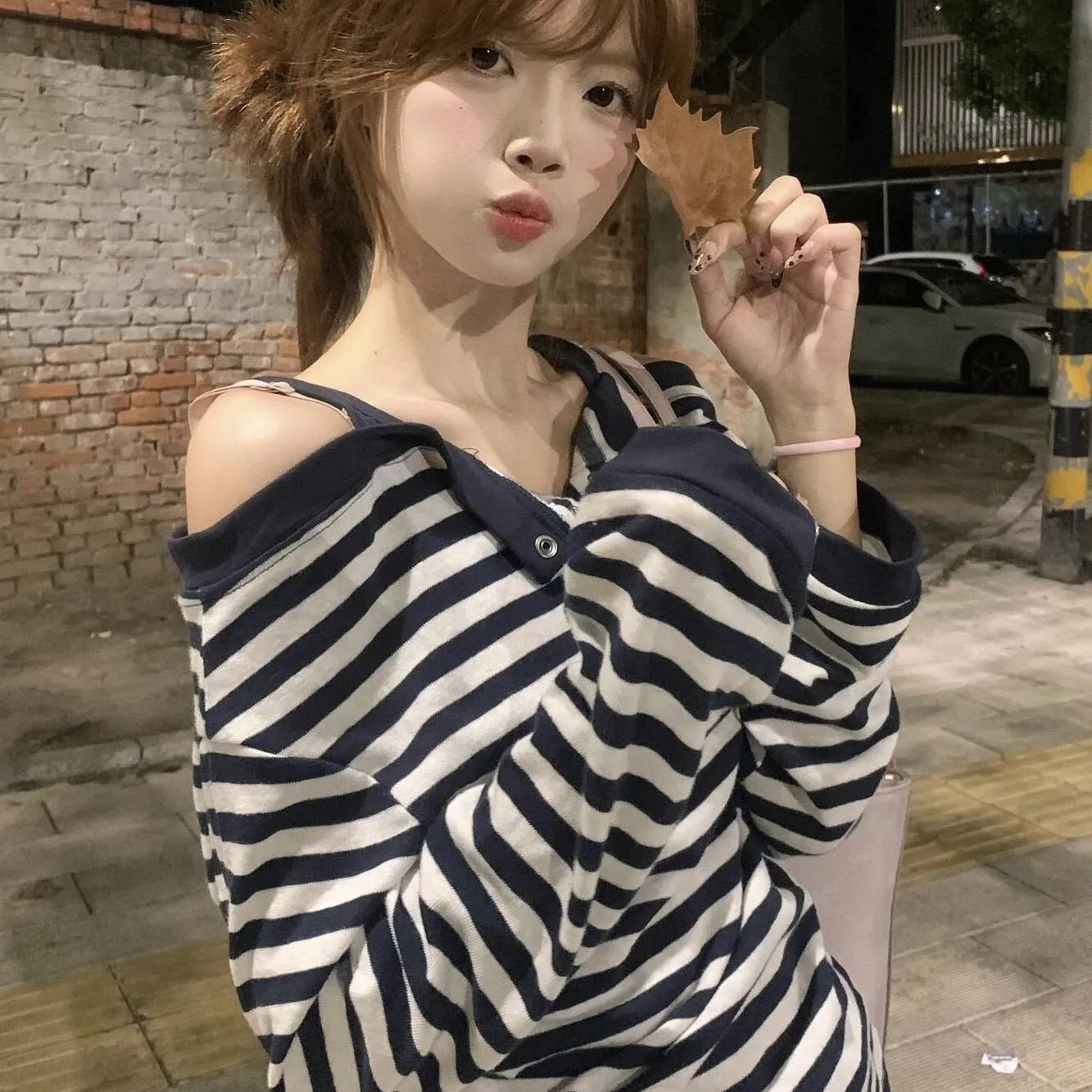 Dark blue women's long-sleeved t-shirt with an oversized fit, showing stripe and embroidery detail on the front.