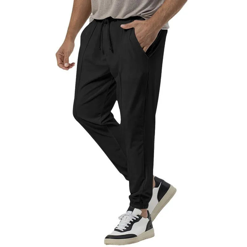 Man wearing grey loose tapered track sweatpants with a casual top