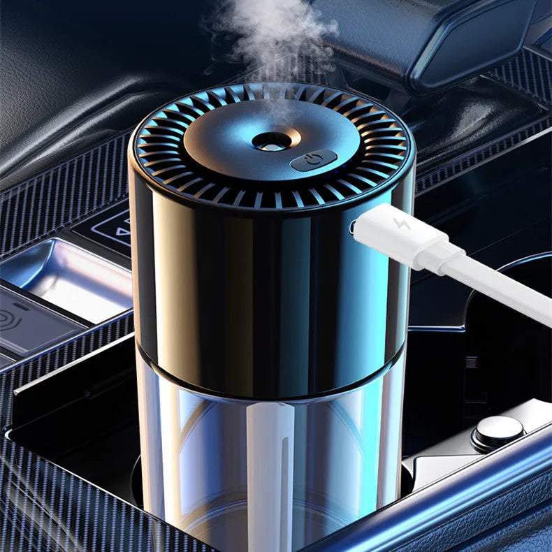 Compact USB plug-in spray perfume humidifier with glass seat on a desk.