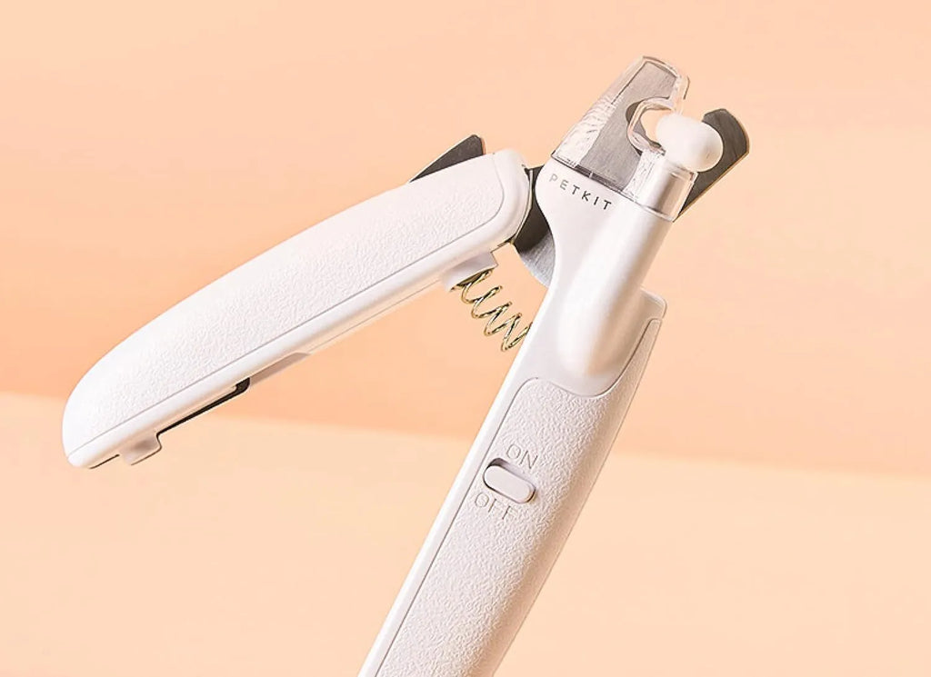 White pet nail clippers with built-in LED light and transparent anti-splash guard.