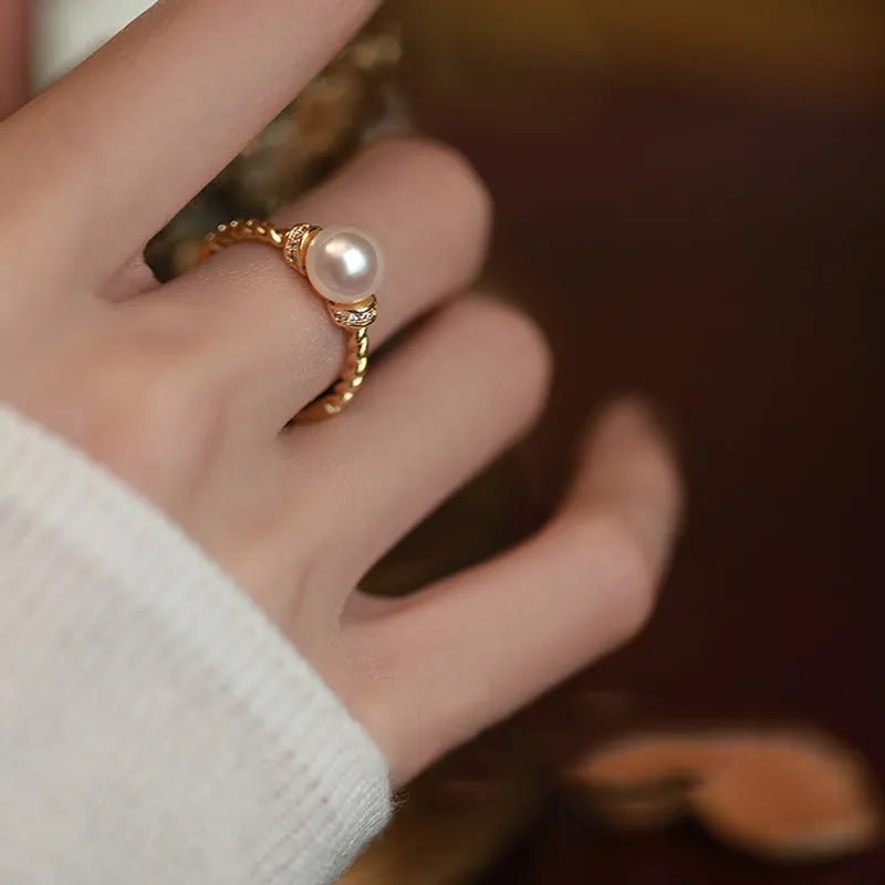 Adjustable antique twist design copper ring with pearl inlay in gold colour.