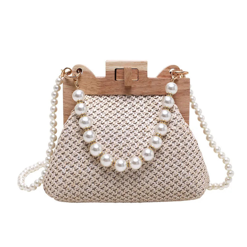 Women's woven straw shoulder bag with pearl chain details showing interior organisation compartments