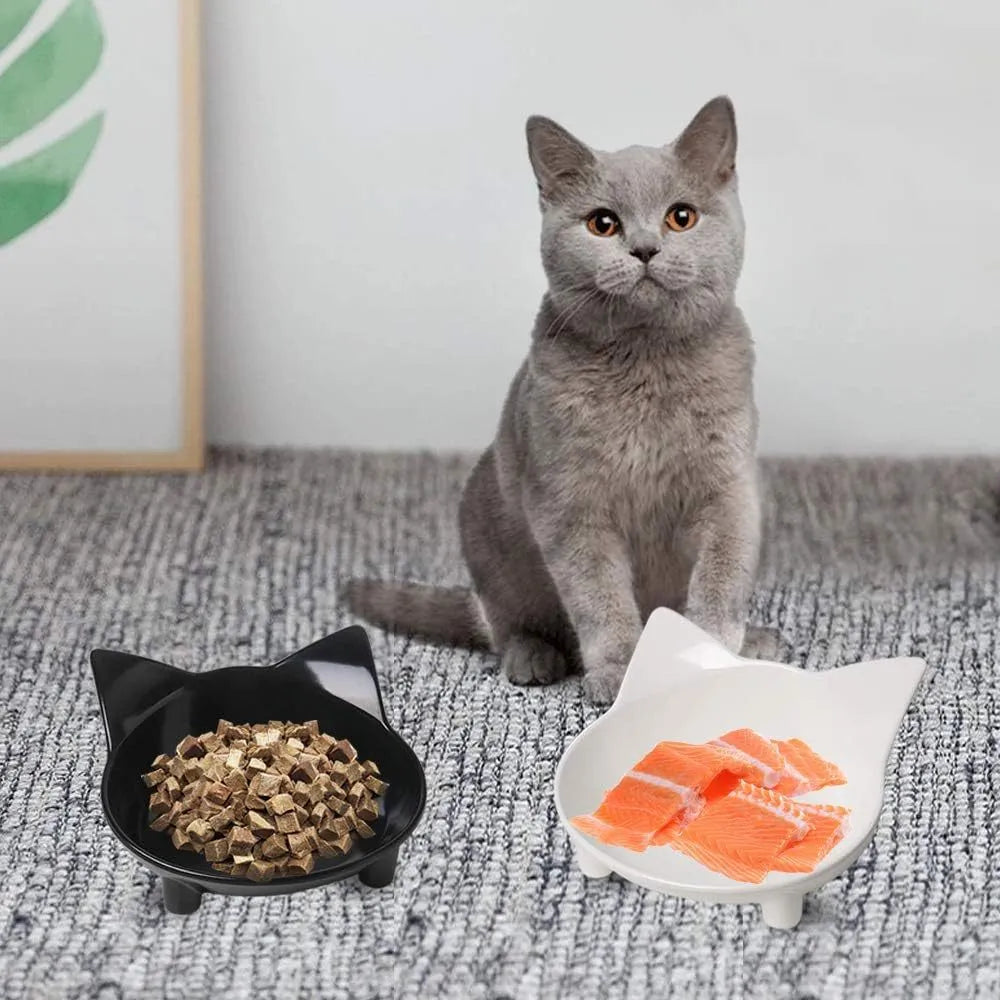 Shallow black melamine cat bowl with non-slip rubber base on a kitchen floor