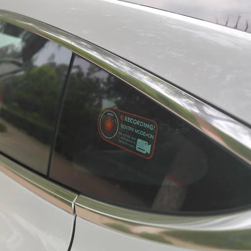 Two white electrostatic warning stickers for Tesla Sentry Mode, each measuring 11 by 5 centimetres.
