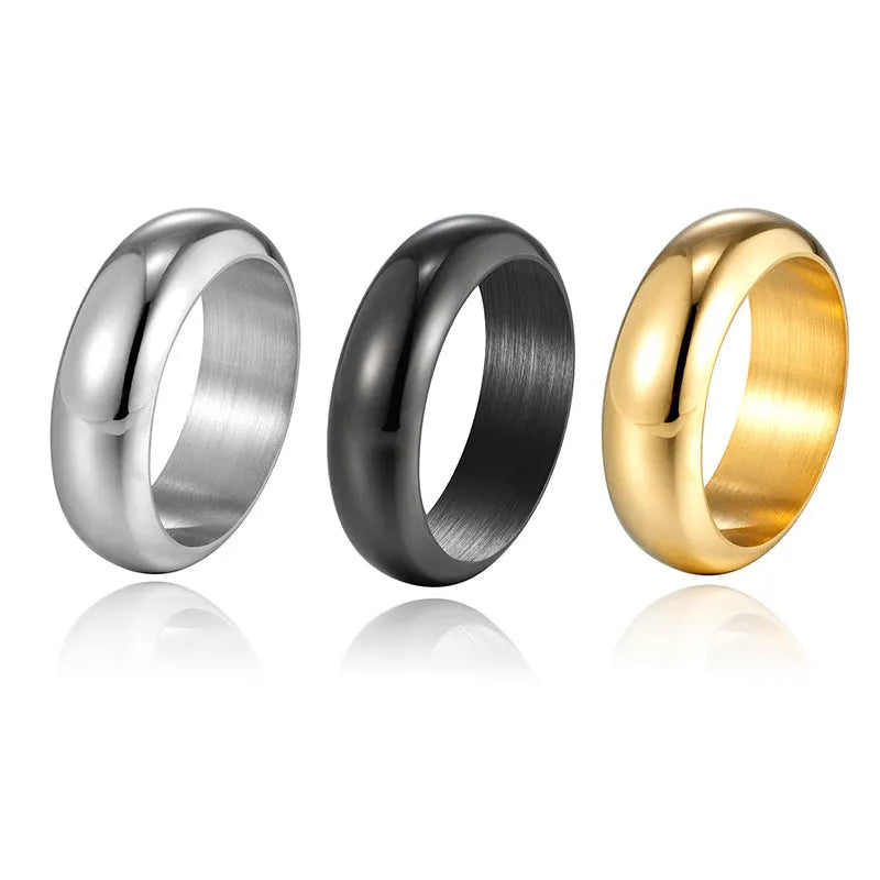 Glossy electroplated titanium steel ring in gold, black, and steel colours on a jewellery background.