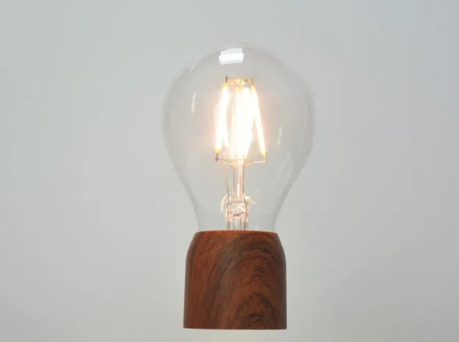 Magnetic levitation floating light bulb on imitation wood base with choice of international plugs.