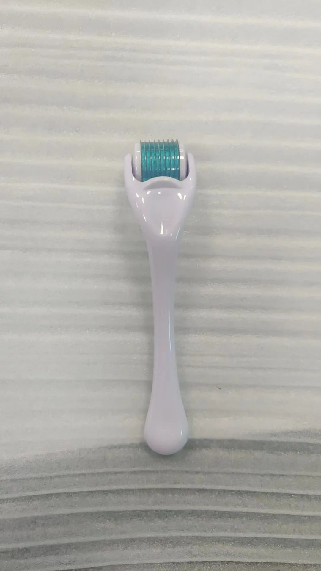 Black handle microneedle roller with purple wheel showing 540 needles, next to white and blue handle options.