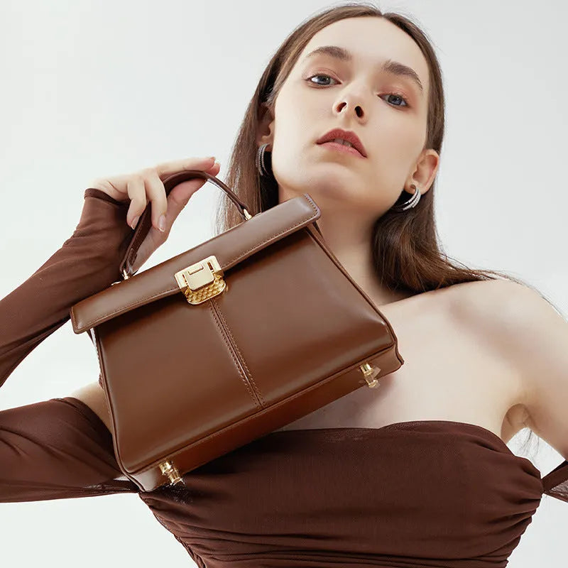 Women's black leather shoulder bag with vachette clasp showing organised interior compartments