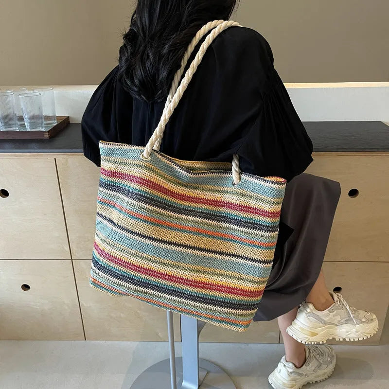 Blue woven nylon shoulder bag with an adjustable strap shown on a model.