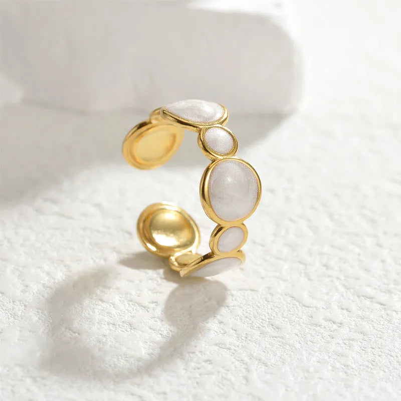 A geometric stainless steel ring with an adjustable opening and an electroplated finish.