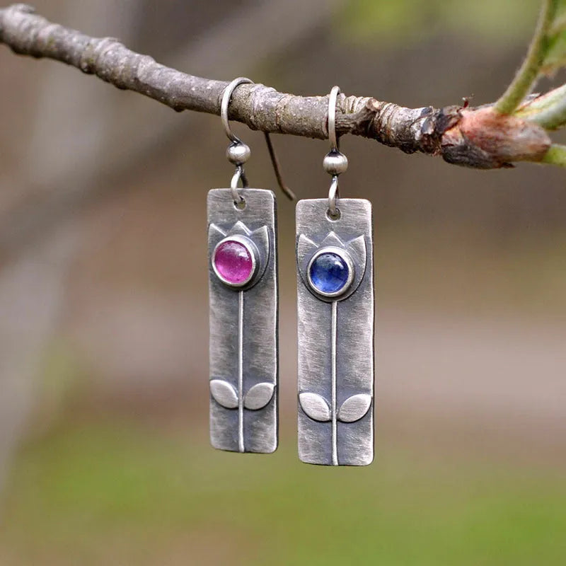 Antique finish red sapphire earrings with a geometric ellipse shape on electroplated metal.