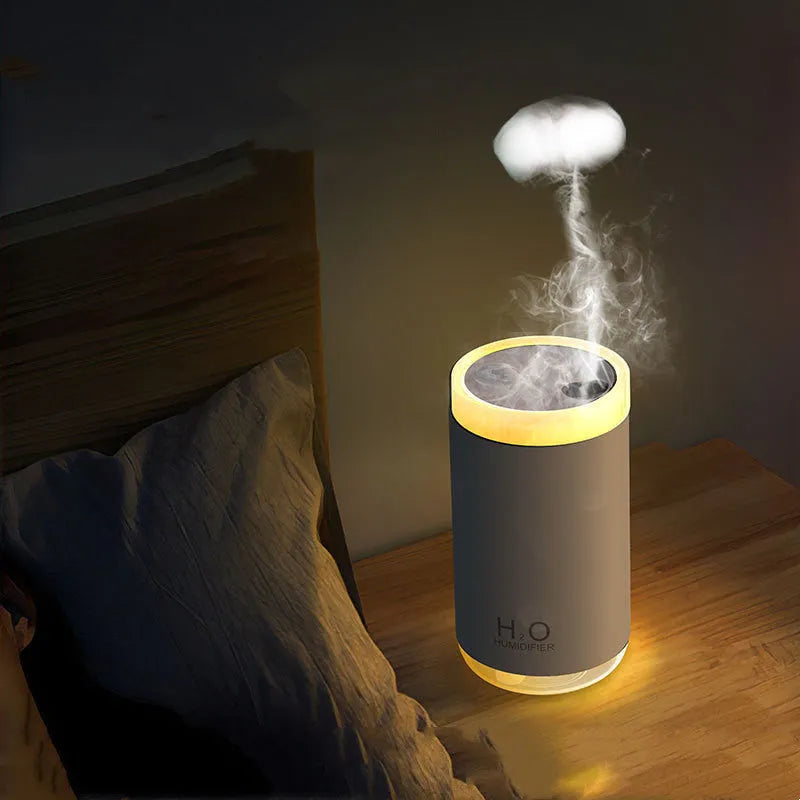 Mini USB jellyfish humidifier with warm night light in white, showing smoke-ring mist output