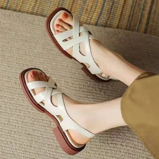 Women's glossy black patent leather sandals with square toe and cross-belt fastening