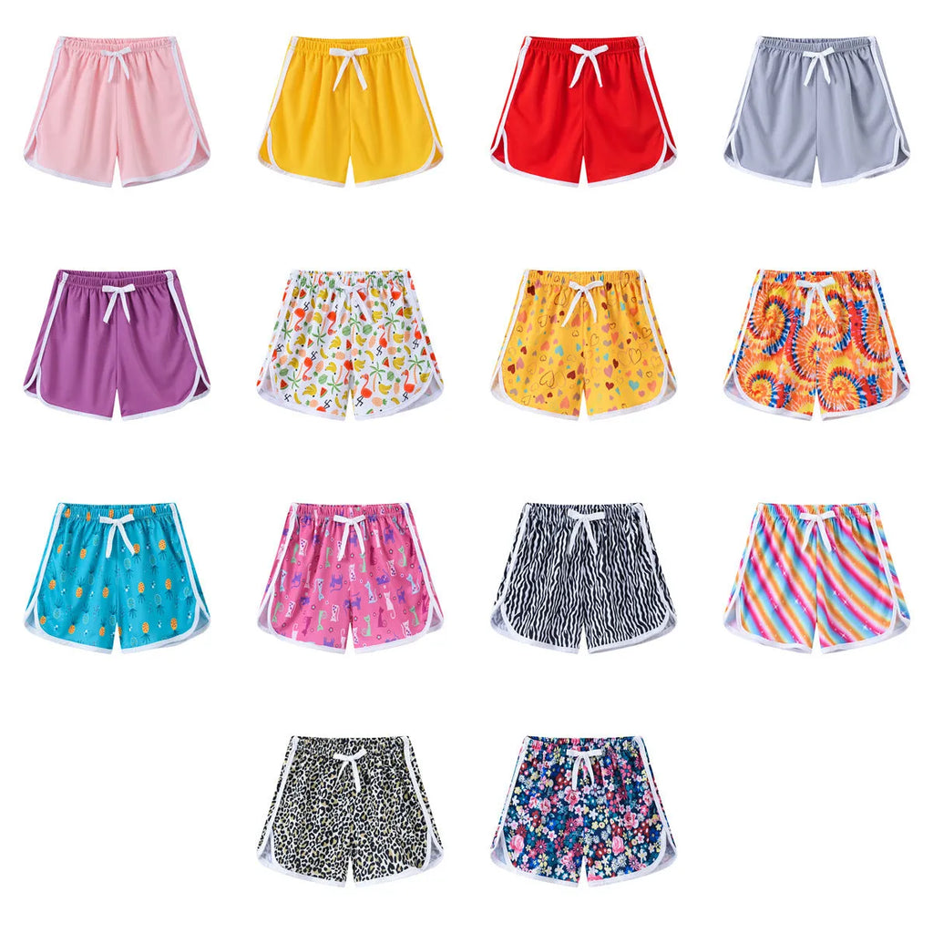 Children's colourful polyester shorts with elastic waistband, showing patterns like stripes, pineapples, and kittens.