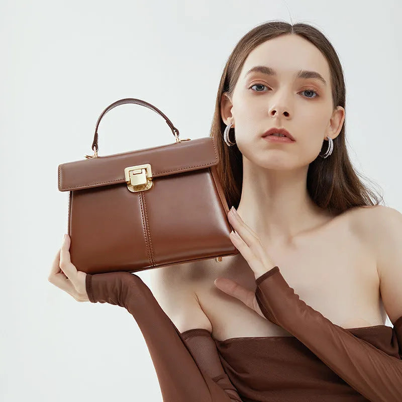 Women's black leather shoulder bag with vachette clasp showing organised interior compartments