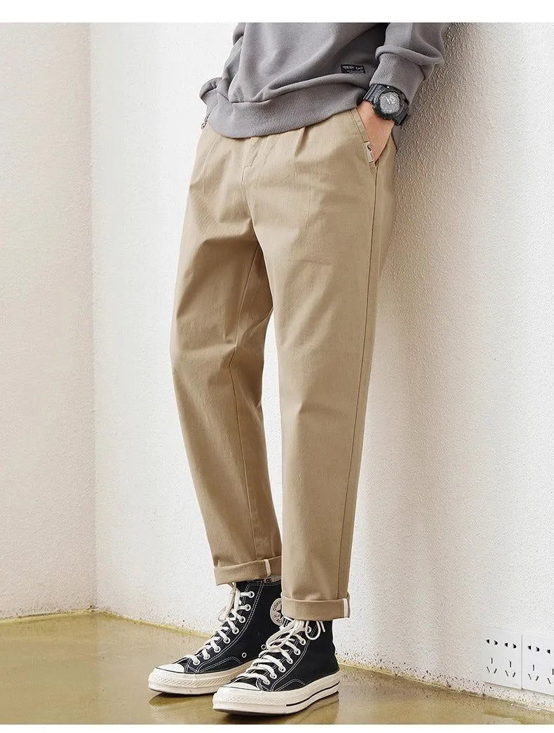 Men's loose wide-leg casual pants in dark khaki with zipper fly and mid-rise waist on a plain background
