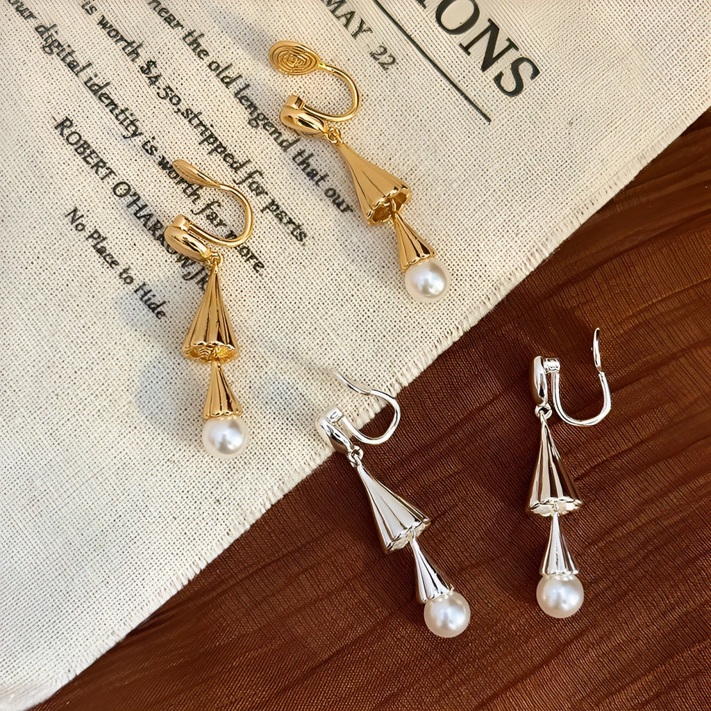 Gold electroplated copper geometric fringe earrings on a woman with long wind chime pearl mosquito coil plate shape close up