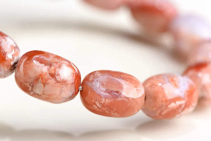 Natural cherry blossom coloured agate barrel bead bracelet with a Ruyi charm.
