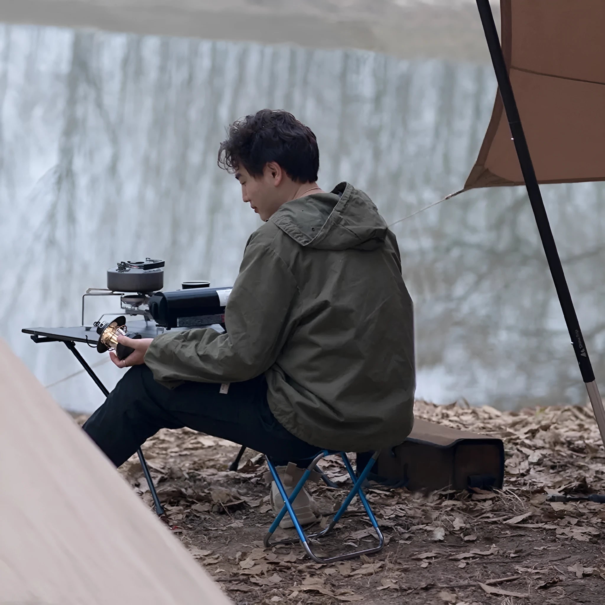 Black ethnic style folding camp stool with 7075 aluminium alloy frame in folded position.