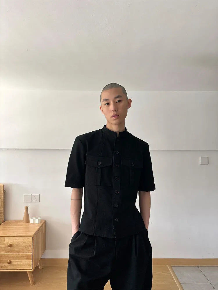 Handmade black half-sleeve hunting shirt with shirt collar on a hanger.