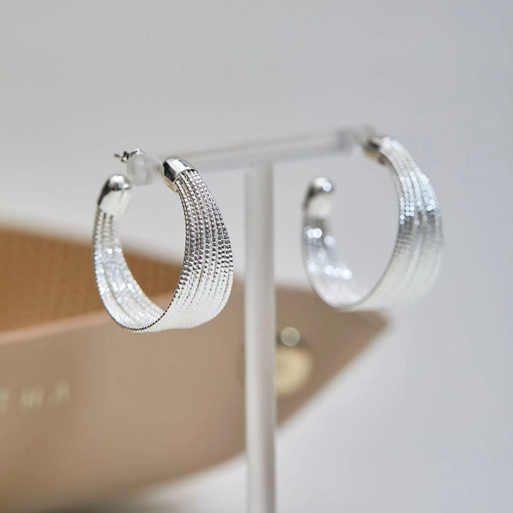Set of geometric multi-layer earrings in gold and silver, showing stud and clip styles on a flat surface.