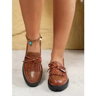 Women's black loafers with a decorative bow on the front.