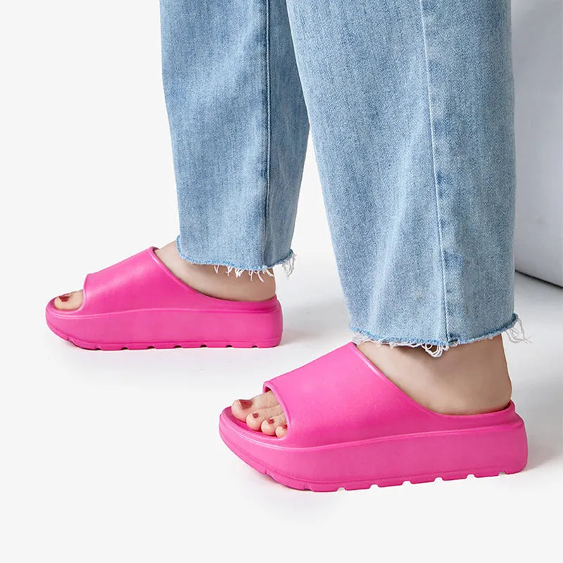 Women's beige fish mouth slippers with a thick sole on a wooden floor.