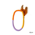 Circular cotton rope cat toy with feathers and catnip measuring 25cm in green and purple colours