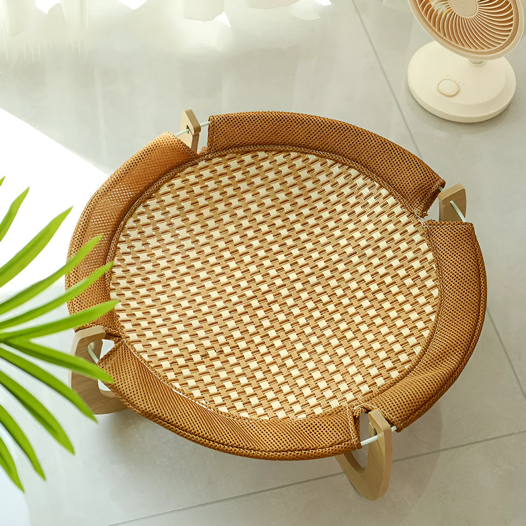 Brown woven rattan square pet bed basket for cats and small dogs on a wooden floor.