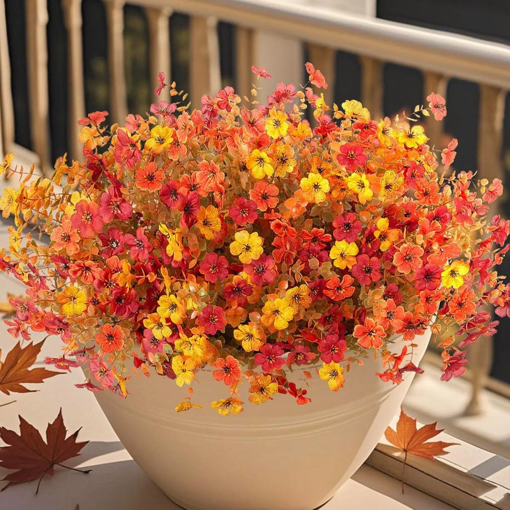 Artificial flower bouquet in autumn orange, yellow, and red colours with detailed plastic and silk construction