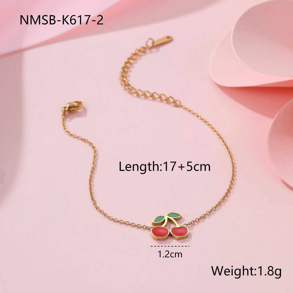 Complete cherry jewellery set showing stainless steel necklace, bracelet, earrings, and ring pieces with electroplated colour finishes