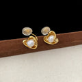Pair of copper heart shaped irregular pearl earrings with electroplating finish on white background