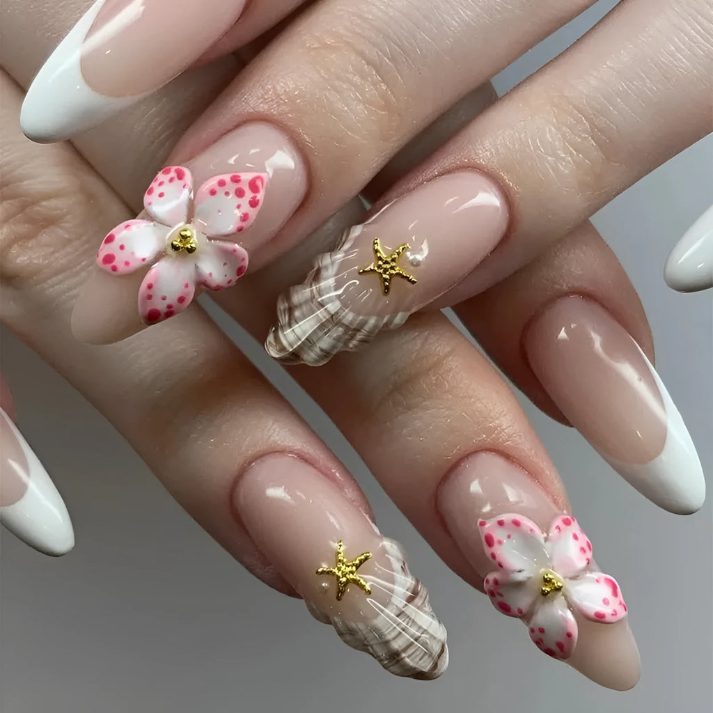 French style press-on fake nails with white tips and decorative pink rock-pattern floral patches on a clear nail bed.