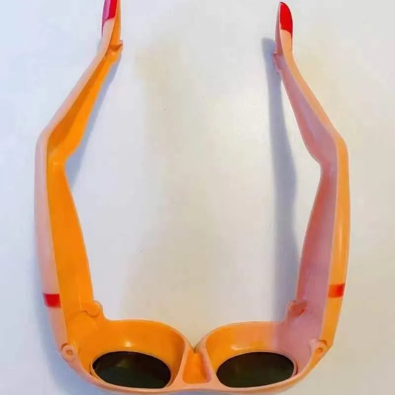 Orange novelty sunglasses with a leg and hip design on a white background.