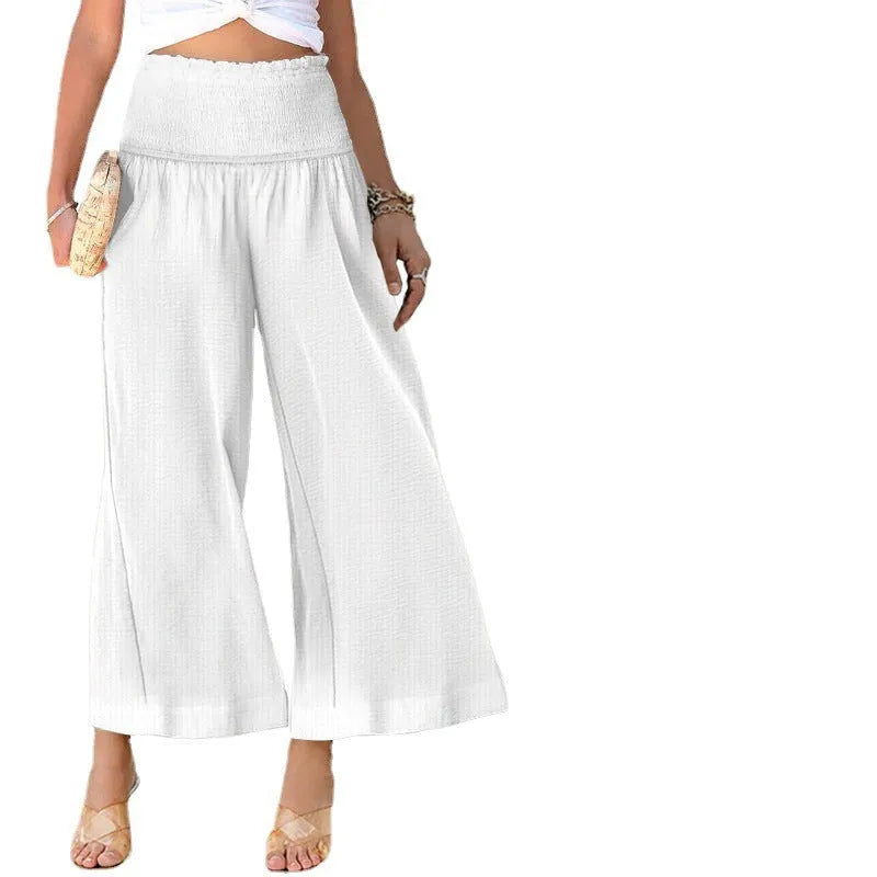 Woman wearing high-waist pleated casual trousers in a cotton-linen blend, showcasing the cropped straight-leg style.