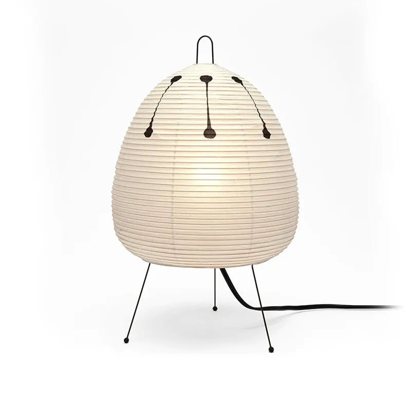 Japanese style table lamp with handmade paper shade and aluminium base on a wooden surface.