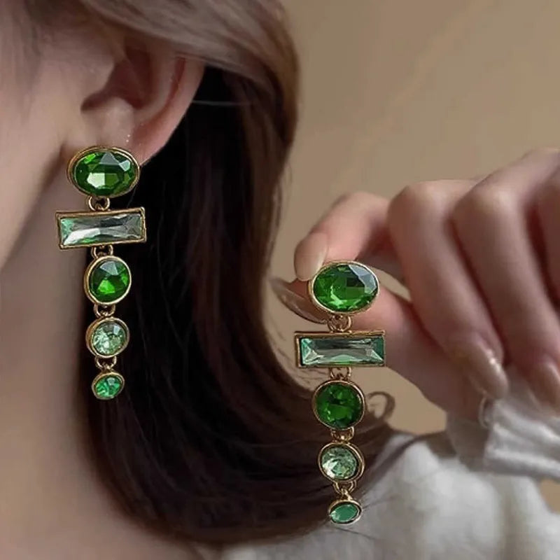 A pair of green gradient alloy earrings with geometric shapes, inlaid zircon stones, and decorative tassels.