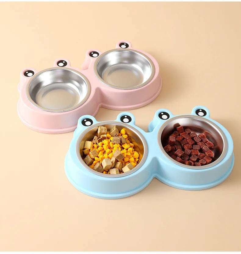 Blue stainless steel frog-shaped double pet bowl for food and water on a floor.
