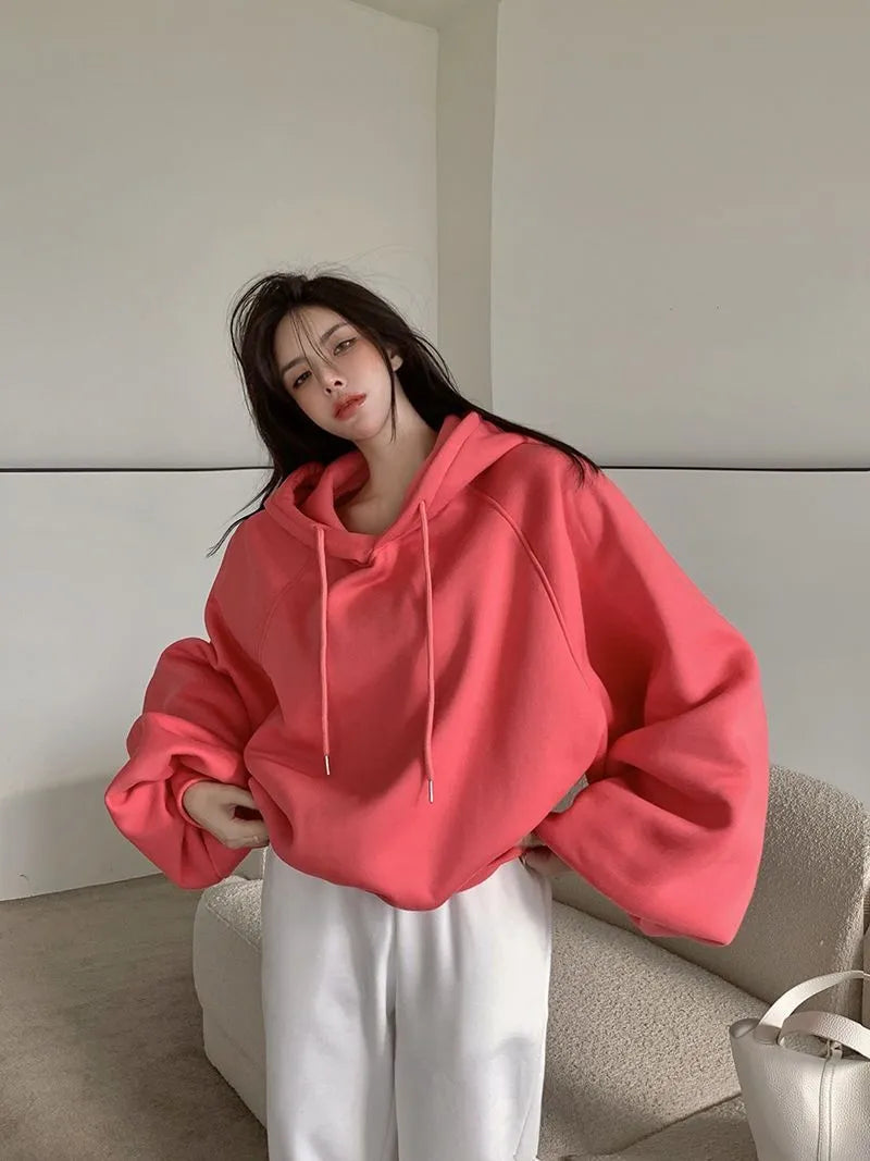 Women's watermelon red sleeveless hooded sweater made from mulberry silk fabric on a hanger