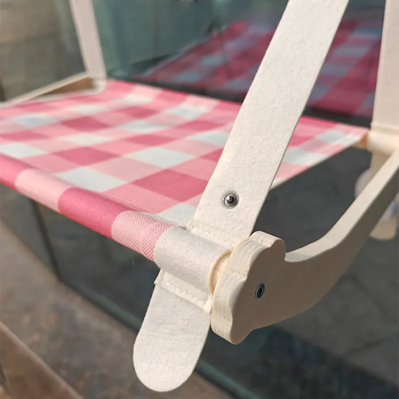 Wooden cat window hammock with suction cups on a glass window