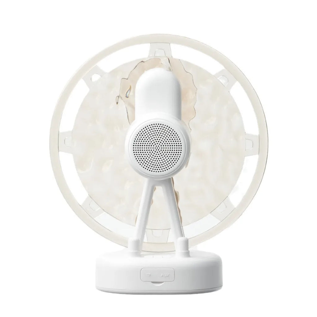 Pink Ferris wheel Bluetooth speaker projecting colourful water ripple light patterns on a surface.