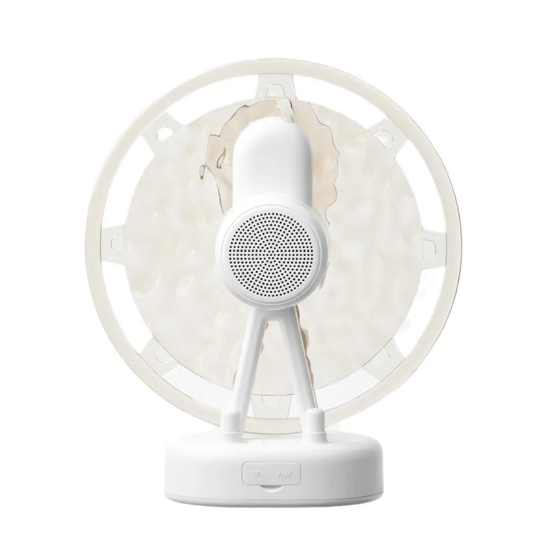 Pink Ferris wheel Bluetooth speaker projecting colourful water ripple light patterns on a surface.