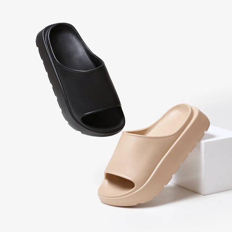 Women's beige fish mouth slippers with a thick sole on a wooden floor.