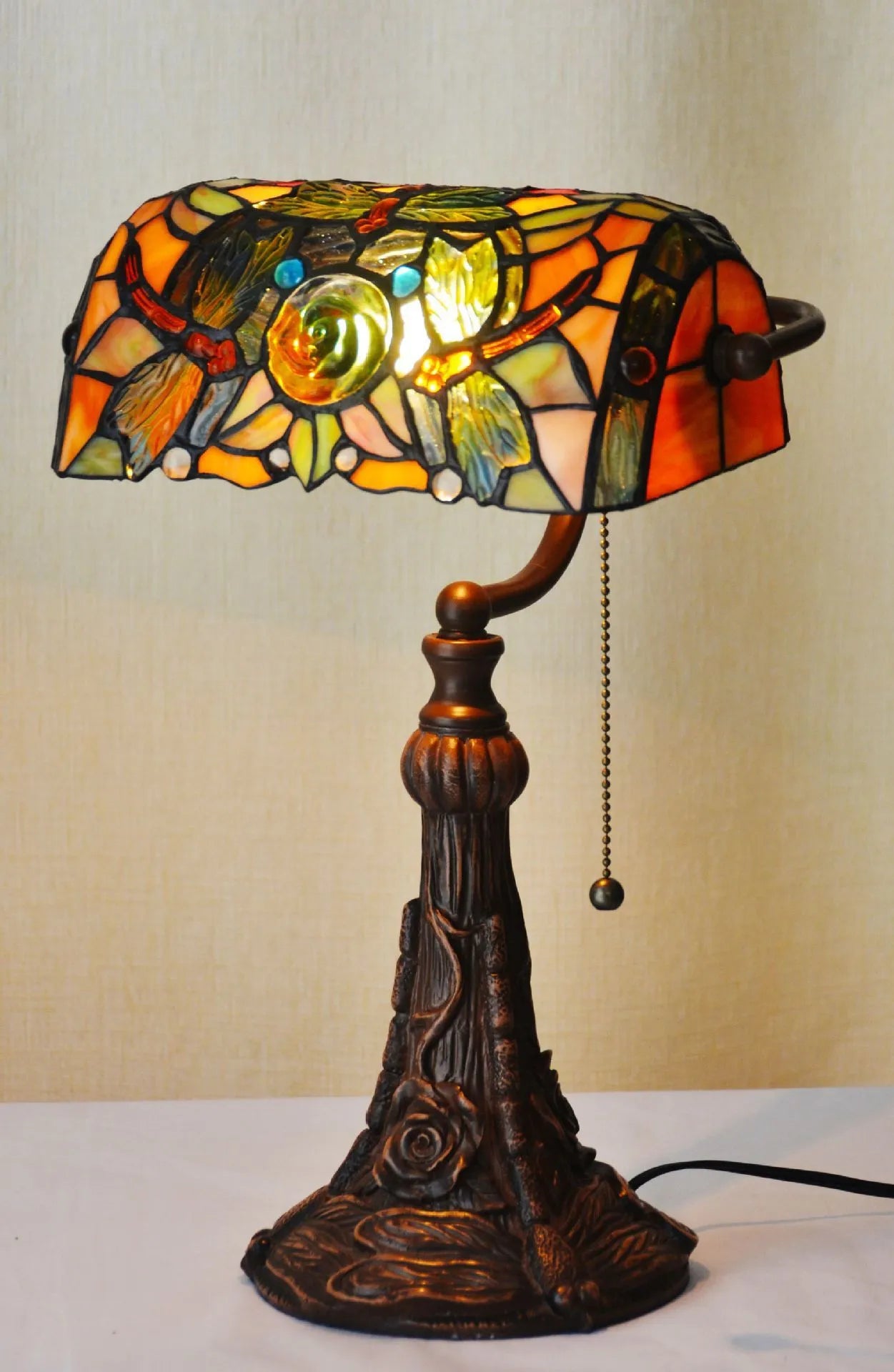 Tiffany style table lamp with coloured stained glass shade on a resin base.