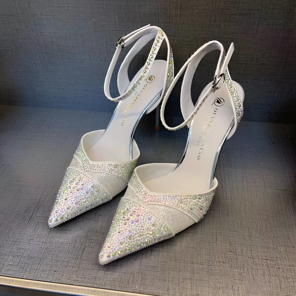 Women's black pointed toe high heels with a hollow stiletto heel and red sole, shown from the side.