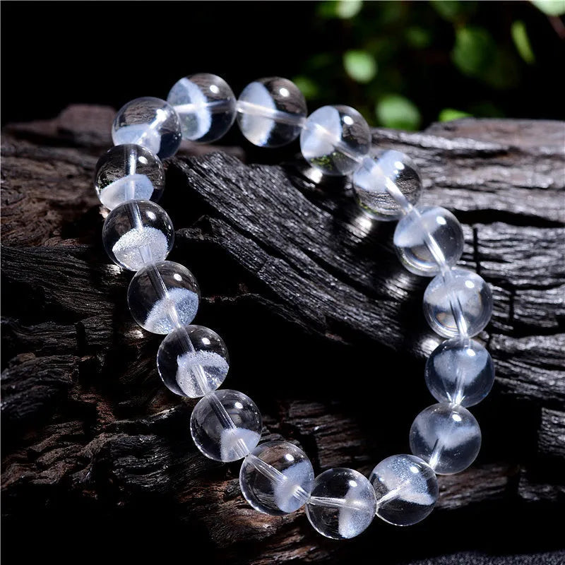Women's white crystal ghost pyramid bracelet with ruyi charm on a wrist, showing bead detail.