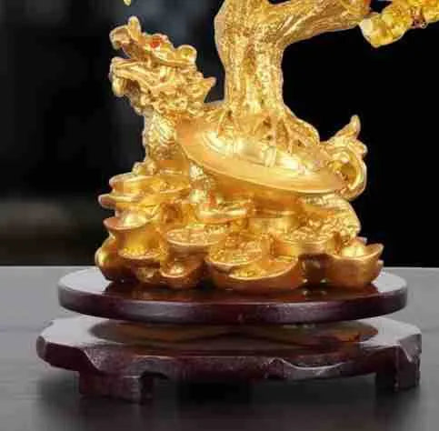 Citrine-coloured resin turtle money tree ornament on a neutral background.